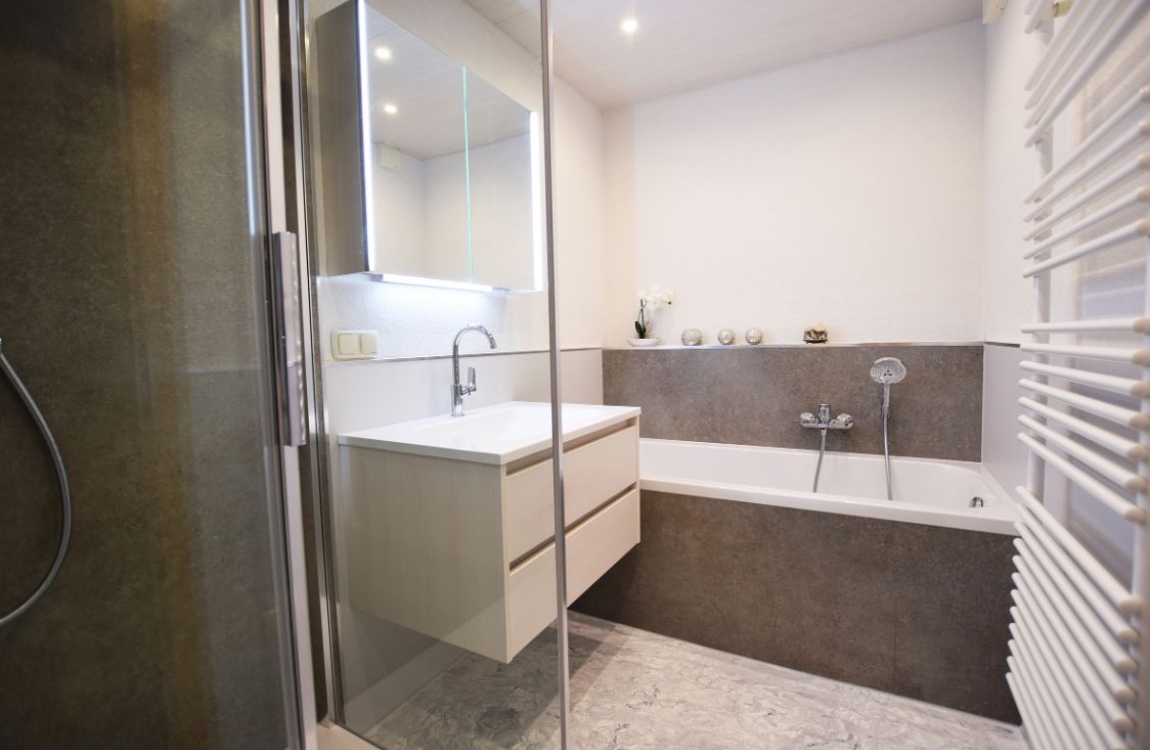 Fugenloses Badezimmer mit Schiefer Platingrau und hellgrauen Platten kombiniert