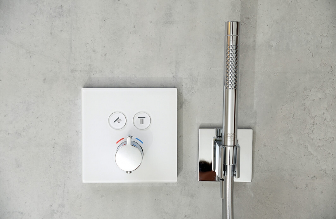 Unterputzthermostat mit Stabhandbrause vor elegantem Sichtbeton Dekor